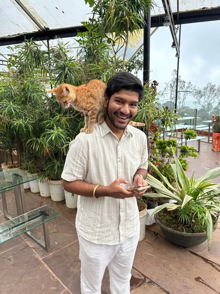 Parth Konde smiling, with a ginger cat perched on his shoulder